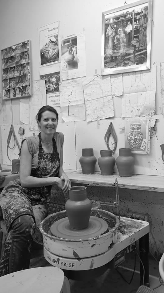 Ceramicist shaping a creation on the wheel in the studio